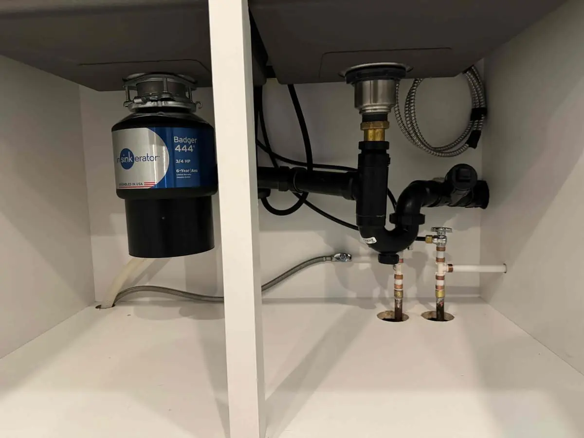 Garburator and drain assembly installed under a kitchen sink — Quick Plumbing & Drain, serving Creemore, ON